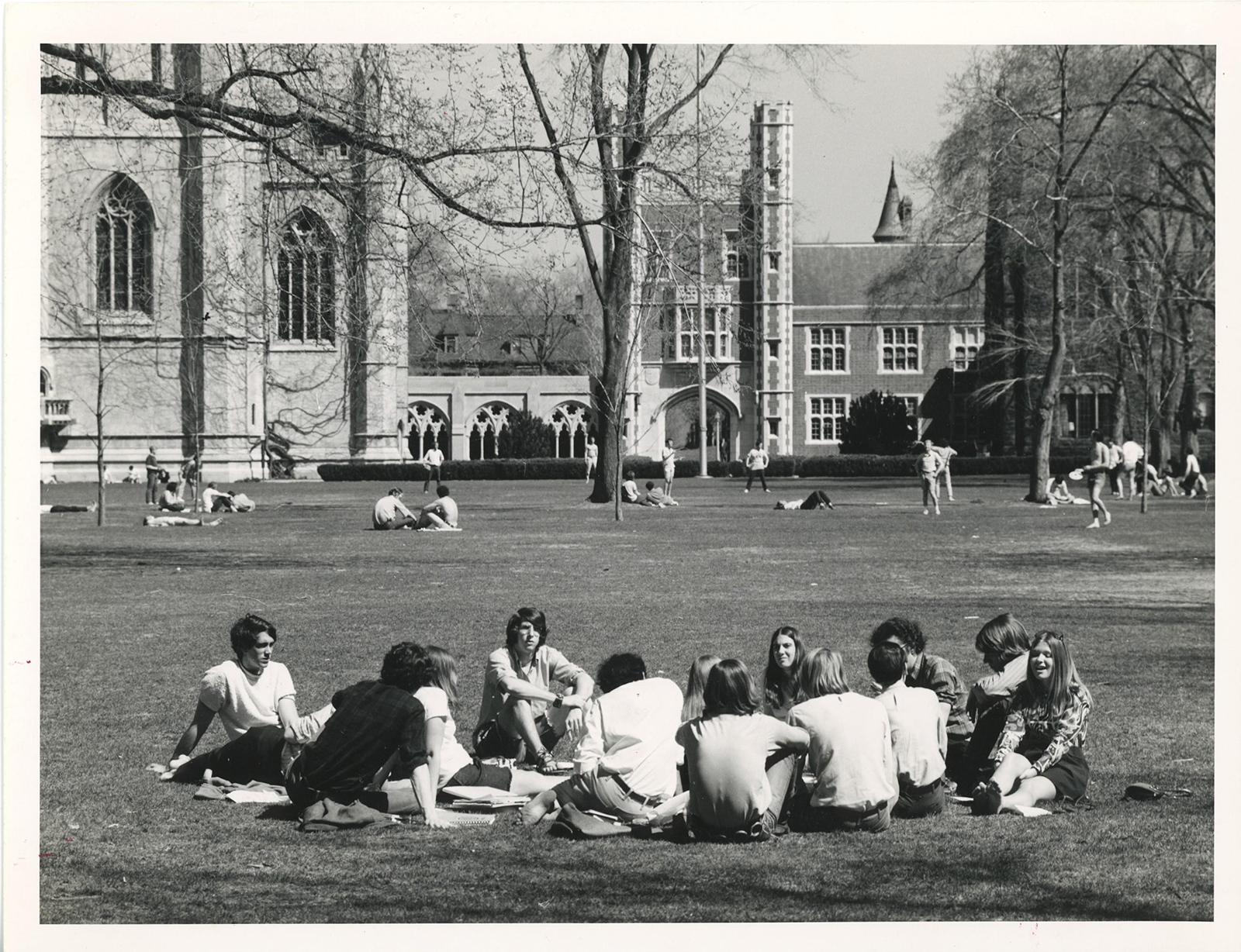 students sitting on the grass on the main quad in a black and white photo from 1972